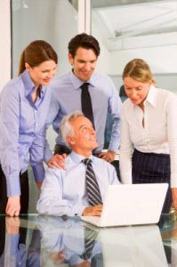 young team members arround old man in office