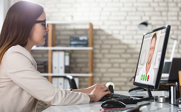 Young Businesswoman Doing Video Conference On Computer At Workplace In Office