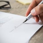 Close up of someone signing a contract