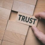 Trust word written on wooden block. Building trust business concept.