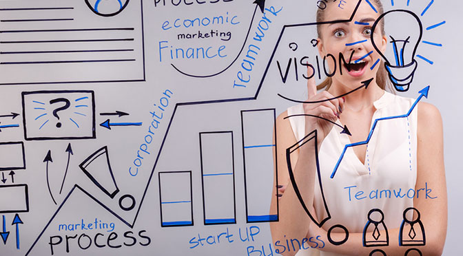 A young beautiful woman with great idea writing on a transparent board in the office, close-up.