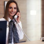 Receptionist answering phone at hotel front desk