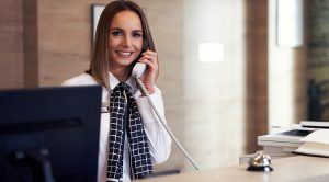 Receptionist answering phone at hotel front desk